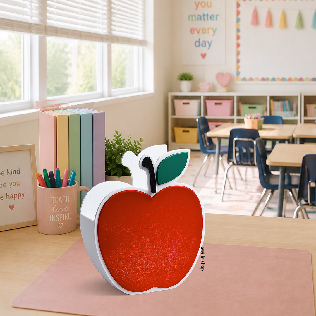 3D printed red apple desk holder with white outline and green leaf