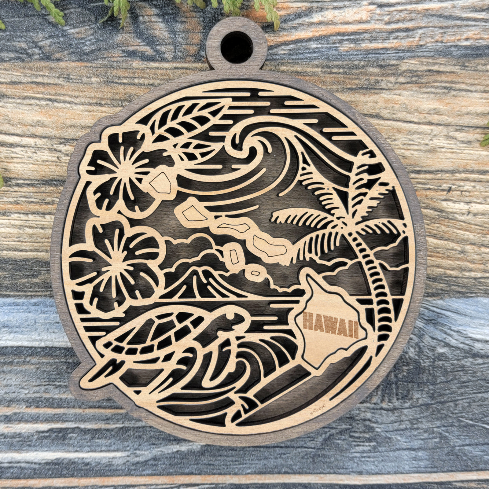Layered Hawaii wood ornament with a laser cut hibiscus flowers, palm tree, sea turtle and ocean waves framing the engraved state shape