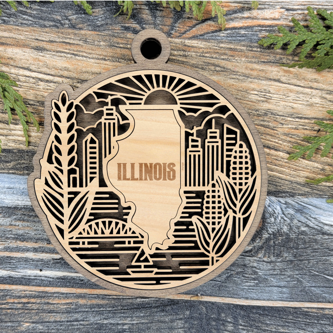 Layered Illinois wood ornament with a laser cut Chicago skyline, wheat, corn and a river bridge framing the engraved state shape