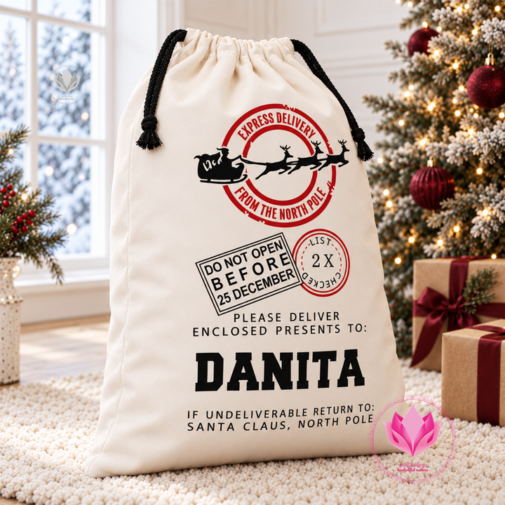 Cream personalized Santa canvas gift sack with drawstring closure and custom Christmas name design.