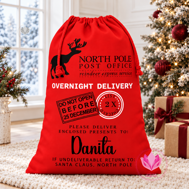 Red personalized Santa canvas gift sack with drawstring closure and custom Christmas name design.