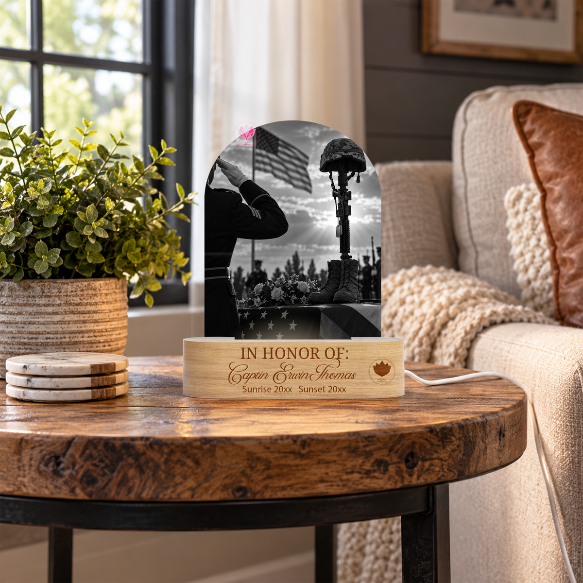 Acrylic arch LED remembrance light with a black-and-white military tribute and engraved wooden base, displayed on a rustic side table.